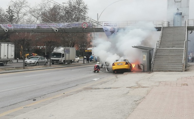 Otomobil ve otobüs durağına çarpan ticari taksi alev aldı