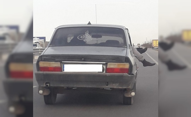 Seyir halindeki otomobilin camından ayaklarını çıkartıp öyle yolculuk yaptı