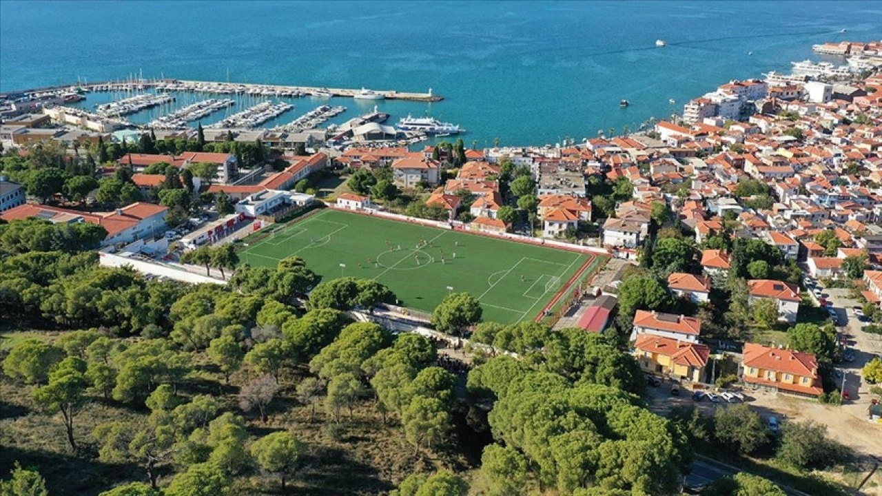 Ağaçların gölgesinde deniz manzaralı tribünde maç keyfi