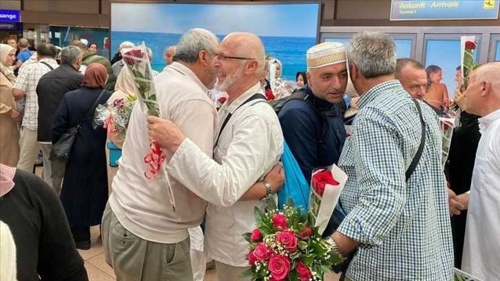 Almanya'da kutsal topraklardan dönen Türk hacılar güllerle karşılandı