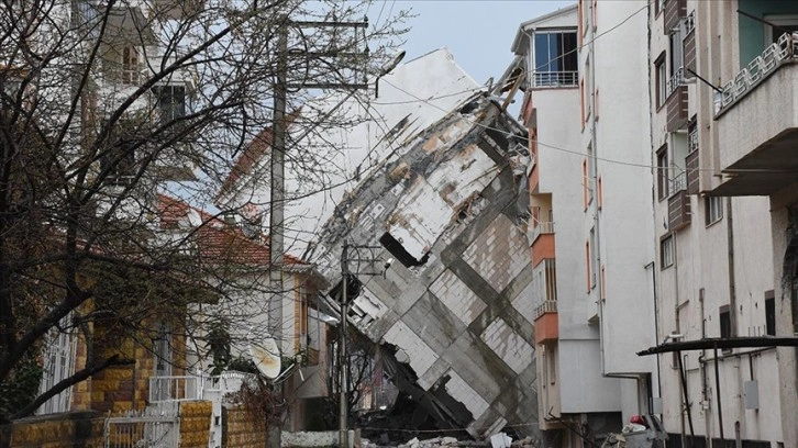 Depremde camları dahi kırılmadan yan yatan binanın yıkımı sürüyor