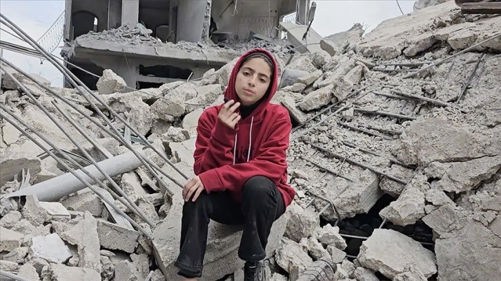Filistinli çocuk, İsrail'in yıktığı evlerinin enkazında eski günlerinden kalma bir hatıra aradı