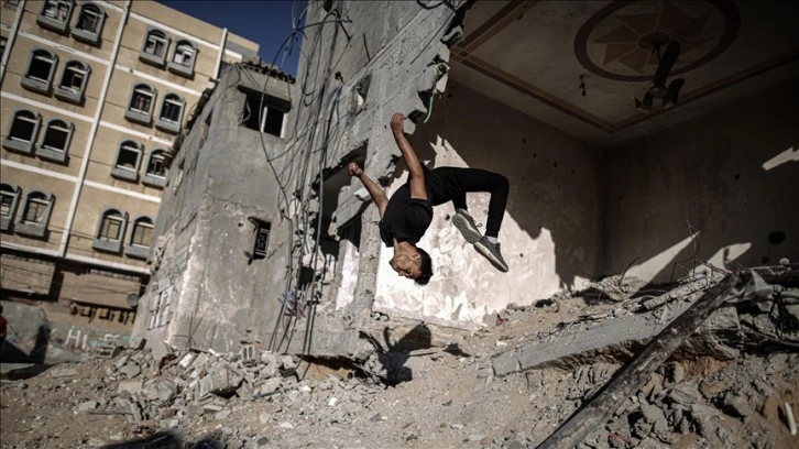 Gazze'de gençler İsrail saldırılarında yıkılan evlerin enkazında 