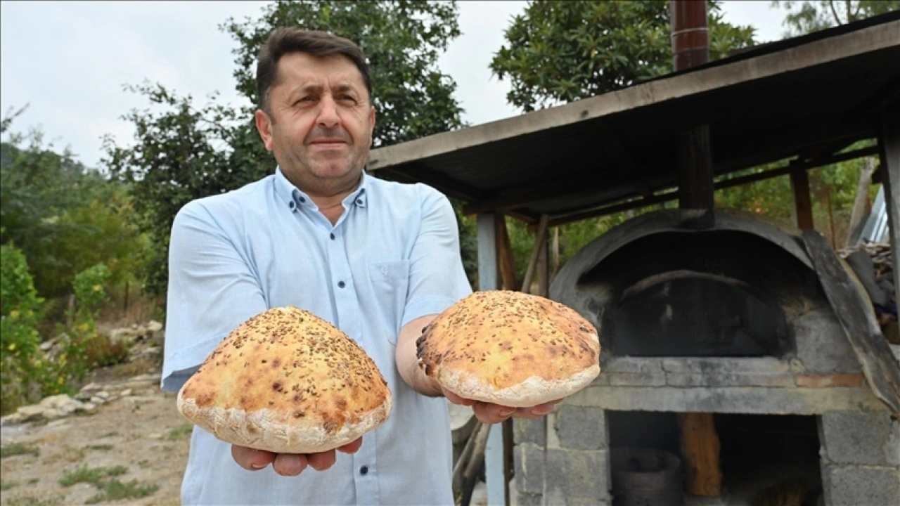 İmam taş fırında pişirdiği ekmekleri köylülere ikram ediyor