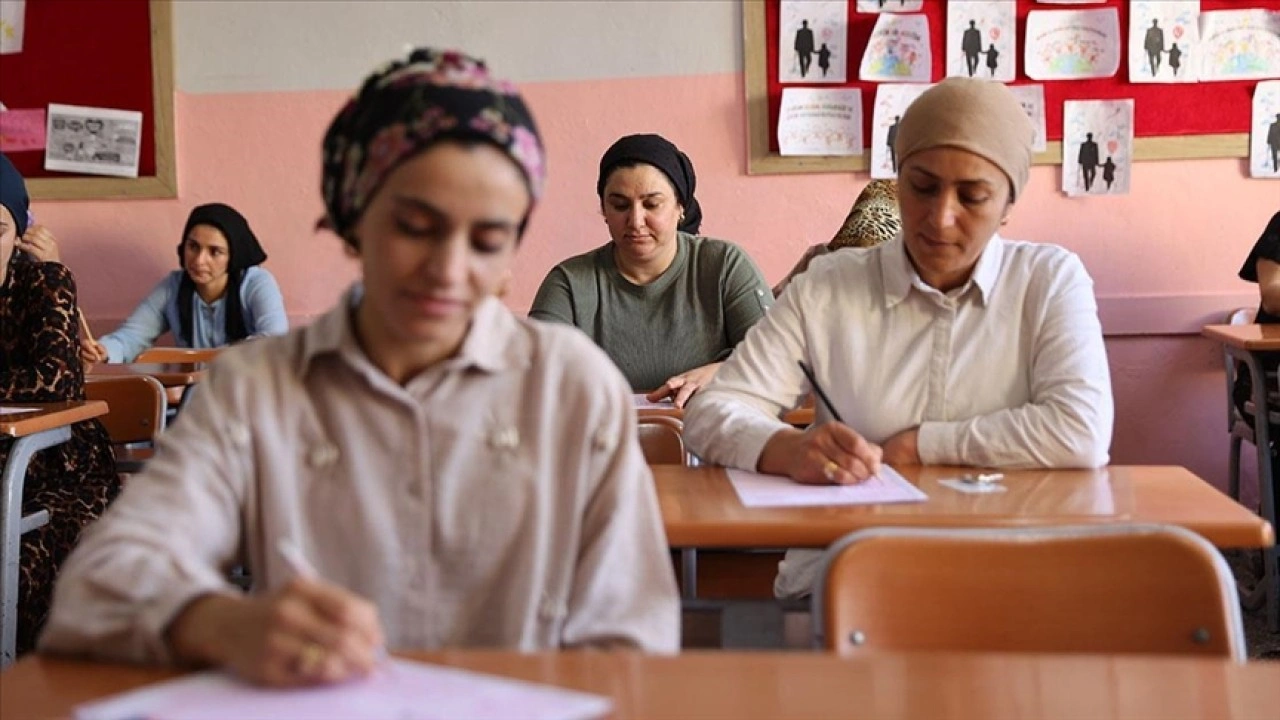 Kitap okuma yarışmasına katılan anneler çocuklarının oturduğu sıralarda sınava girdi