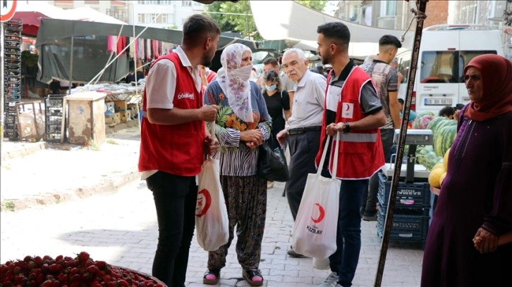 Pazar alışverişi yapan yaşlıların eşyalarını Kızılayın gönüllü gençleri taşıyor
