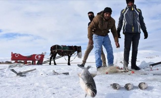 Atlı kızaklarla ulaştıkları gölde buzu kırıp balık avlıyorlar