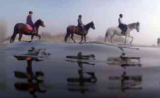 Uluabat Gölü&#039;nde dizlerine kadar suya giren atların sırtında &#039;safari&#039; keyfi