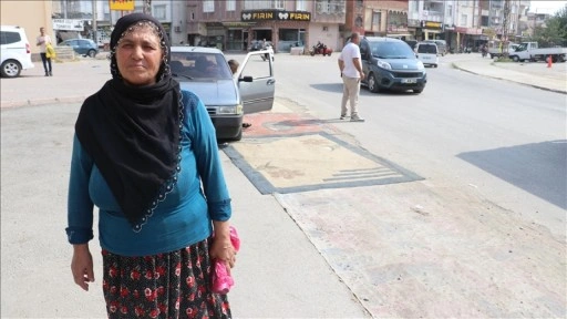 Adana'da tozdan rahatsız olan kadın yoldaki çukurları halıyla kapattı