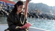 Balıkçı kadın denizde de kitap okuyor