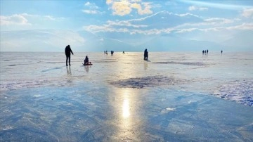 Buzla kaplı Çıldır Gölü'ne gelen turistler eğlenceli zaman geçiriyor