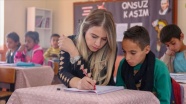 Elif öğretmen okuma yazma öğrettiği çocuklar ve anneleriyle kitap okuyor