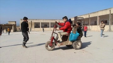 Felçli küçük Cesim, babasının tahtadan yaptığı tekerlekli sandalyeyle okula gidiyor
