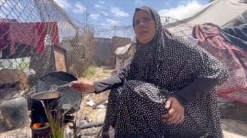 Filistinli kadın çocuklarına yemek pişirebilmek için yakacak olarak çöpleri kullanıyor