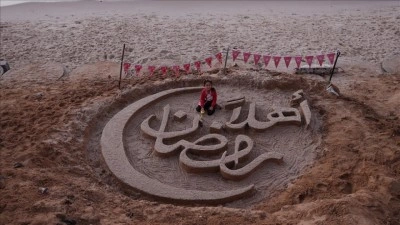 Gazzeli sanat&ccedil;ı sahilde "Hoş geldin ramazan" yazısıyla umudunu yansıttı