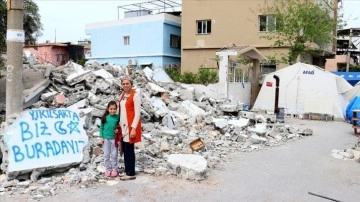 Hataylı kadın "Yıkılsak da biz buradayız" yazdıkları hasarlı evinin önünden ayrılmıyor