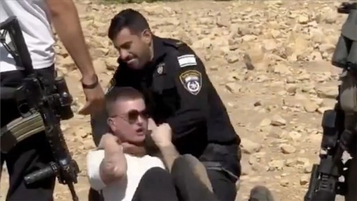 İsrail polisi, Filistin topraklarını gasbeden İsraillilere engel olmak isteyen aktivisti darbetti