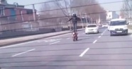 Trafikte motosiklet üzerinde ayağa kalkan sürücü kamerada
